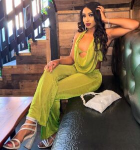 Tampa hair extensions client modeling the benefits of a sew in weave in green jumpsuit