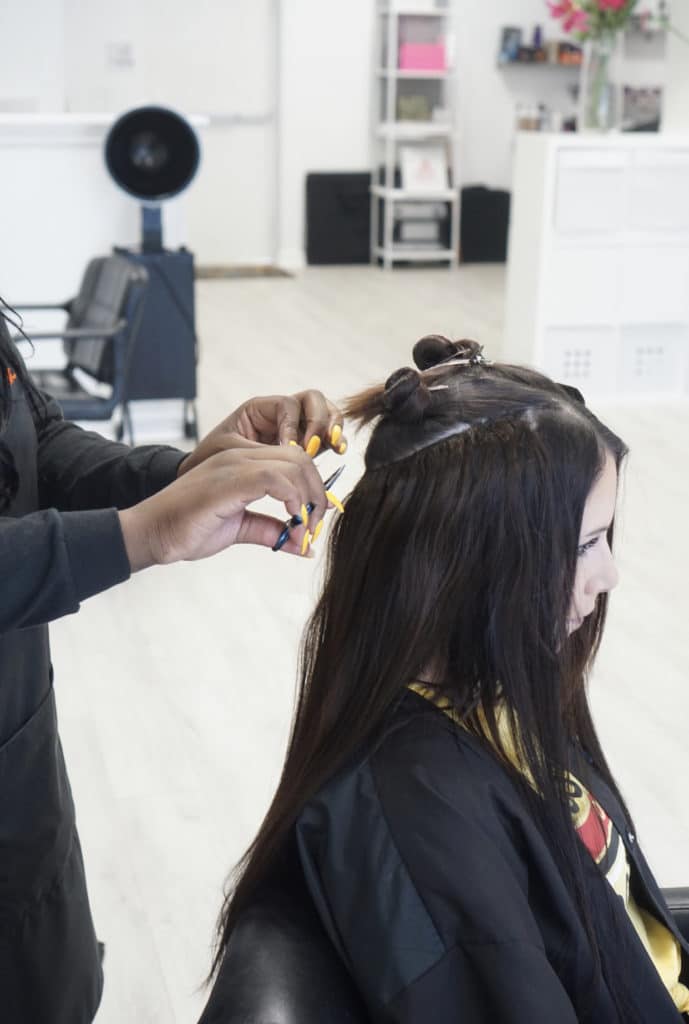 Best hair stylist in Tampa installing hand-tied extensions