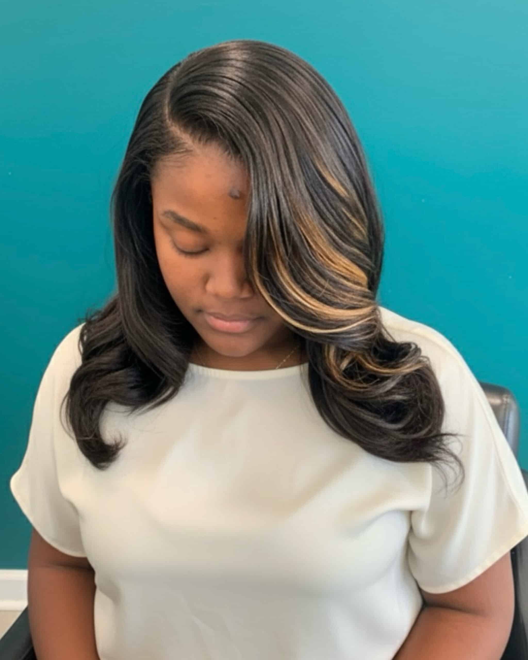 Woman with side-parted traditional sew-in styled in smooth curls